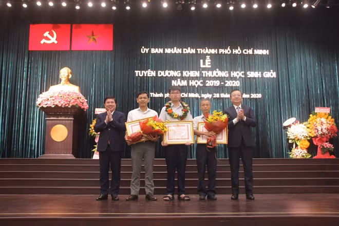 Học sinh Nguyễn Mạc Nam Trung cùng giáo viên nhận phần thưởng của UBND TP.HCM.