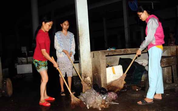 Bà Liên cùng hai cô con gái quét dọn, kiếm sống ở chợ