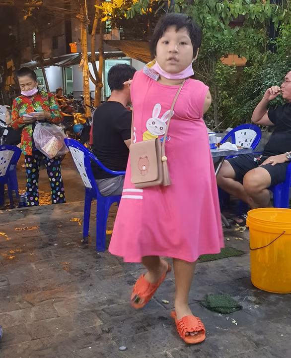 Bé Ân kẹp vé số đi bán - Ảnh: DIỆU QUÍ