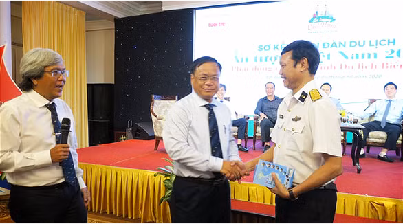 Chủ tịch UBND huyện Hoàng Sa Võ Ngọc Đồng (giữa) tặng sách cho Đại tá Lê Nam Sơn, Phó Lữ đoàn trưởng, Lữ đoàn 125, Bộ tư lệnh Vùng 2 Hải quân (phải) - Ảnh: T.T.D
