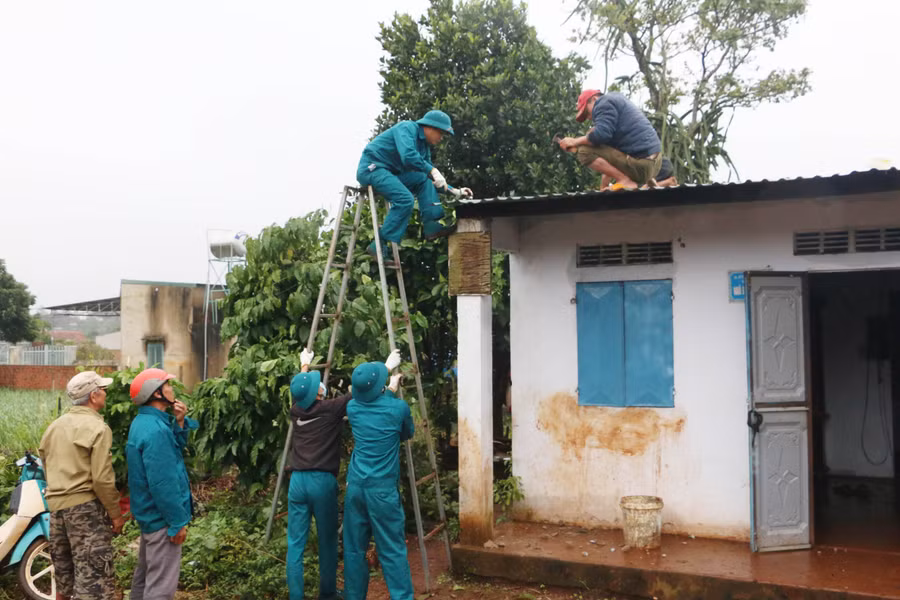Lực lượng dân quân xã Biển Hồ (TP. Pleiku) cùng người dân hỗ trợ lợp lại mái nhà bị tốc mái. Ảnh: Quang Tấn