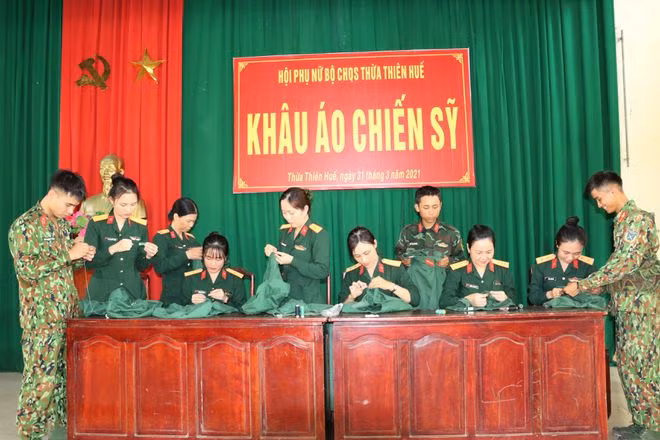 Hướng dẫn các chiến sĩ trẻ cách khâu áo. Ảnh: TRẦN TÌNH