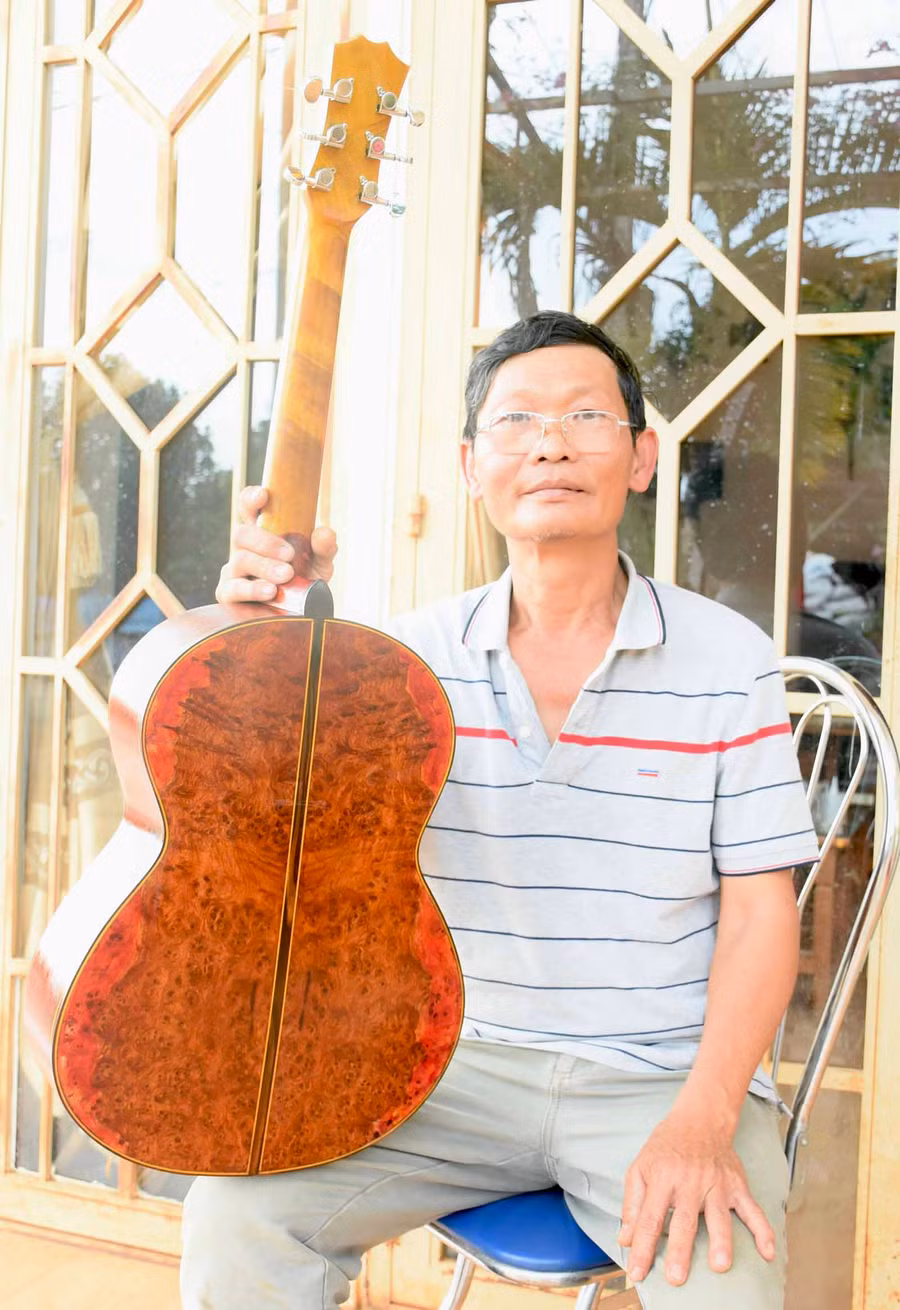 Ông Tam Lang bên chiếc đàn guitar đầu tiên chế tác bằng gỗ nu hương và pơ mu