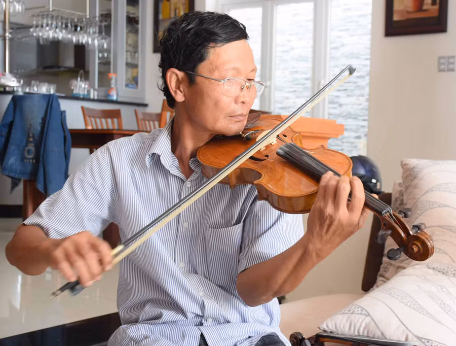 Ông Vũ Văn Tam Lang say sưa biểu diễn cùng chiếc đàn violon do chính ông chế tác. Ảnh: Phương Duyên