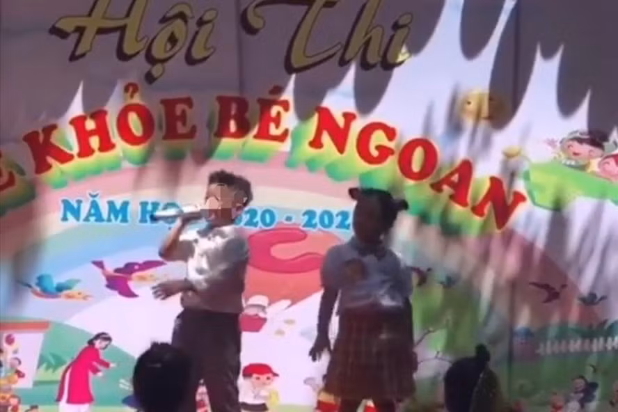 Hai bé đang theo học Trường Mầm non Hoa Sen (TP.Buôn Ma Thuột, tỉnh Đắk Lắk) hát trên sân khấu nhạc không phù hợp với lứa tuổi. Ảnh: Cắt từ clip