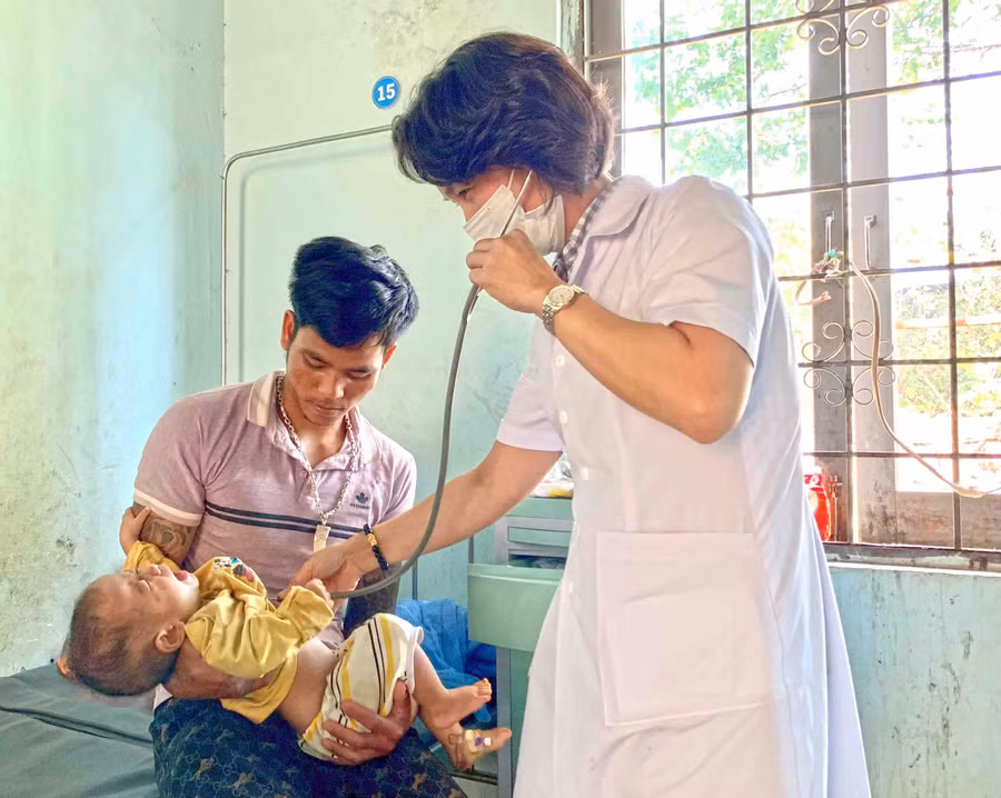Bác sĩ Khoa Nội-Nhi-Nhiễm (Trung tâm Y tế huyện Mang Yang) thăm khám cho bệnh nhi bị viêm phổi trên nền suy dinh dưỡng. Ảnh: Như Nguyện