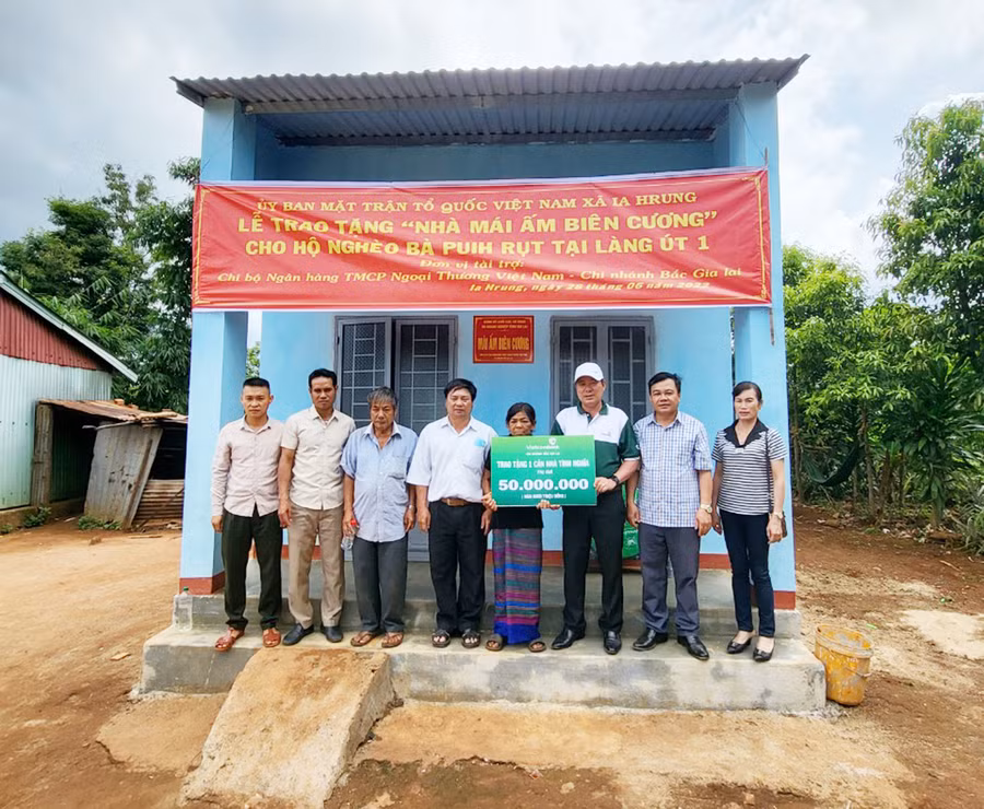  Đại diện lãnh đạo Vietcombank Bắc Gia Lai trao tặng nhà Mái ấm biên cương cho gia đình bà Puih Rụt. Ảnh: Sơn Ca