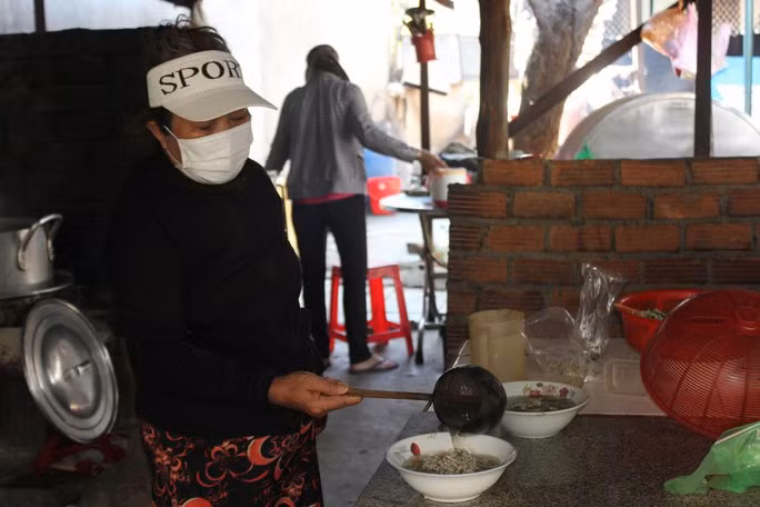 Bà Phạm Thị Kim Liên múc don bằng gáo dừa cho khách. Bà Phạm Thị Kim Liên múc don bằng gáo dừa cho khách