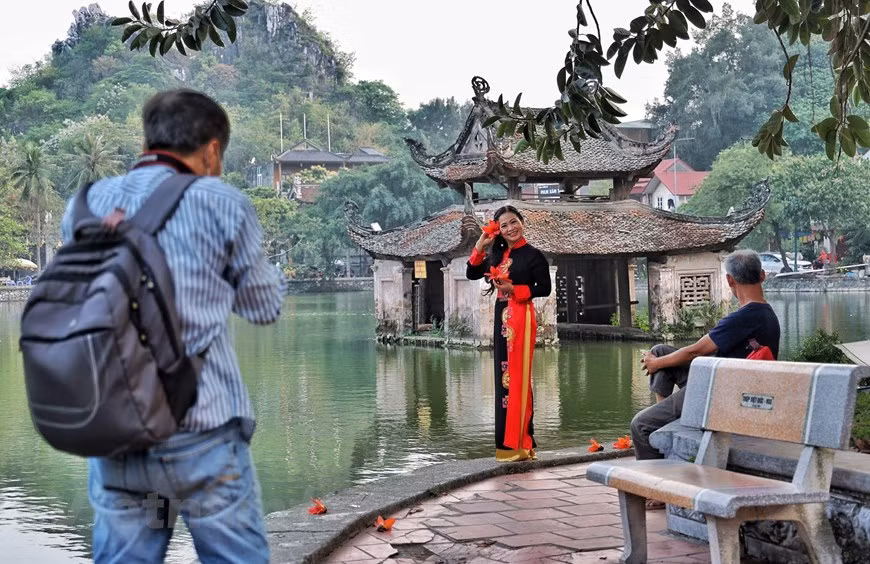 Không chỉ các nhiếp ảnh gia thường tìm đến đây mỗi mùa hoa mà 'một nửa thế giới' cũng về dưới bóng cây 'khoe sắc.' (Ảnh: Xuân Mai/Vietnam+)