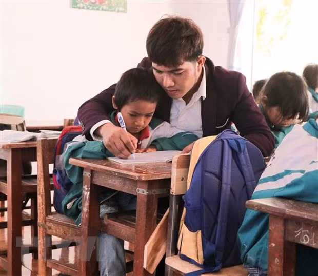 Thầy giáo Tưih rèn chữ cho học sinh tiểu học. (Ảnh: Hồng Điệp/TTXVN)