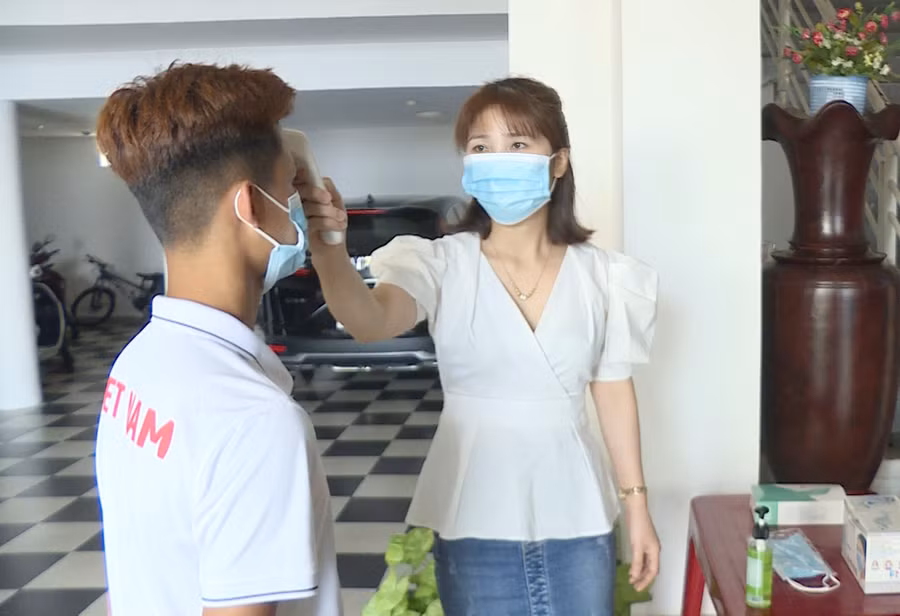 Nhân viên khách sạn Thanh Bình (phường Tây Sơn, TP. Pleiku) đo thân nhiệt cho VĐV đoàn Thanh Hóa. Ảnh: Thiên Di 