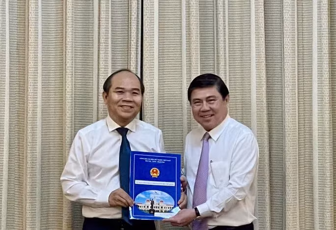 Chủ tịch UBND TP Nguyễn Thành Phong (bìa phải) trao quyết định cho ông Trần Văn Bảy