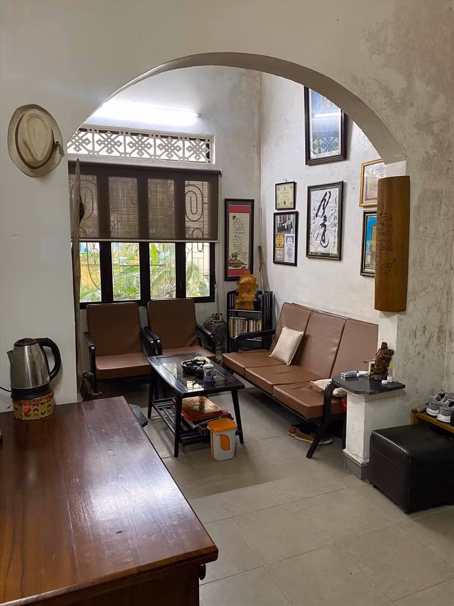 Không gian phòng cổ kính, tông trầm và được bày trí nhiều tranh ảnh.