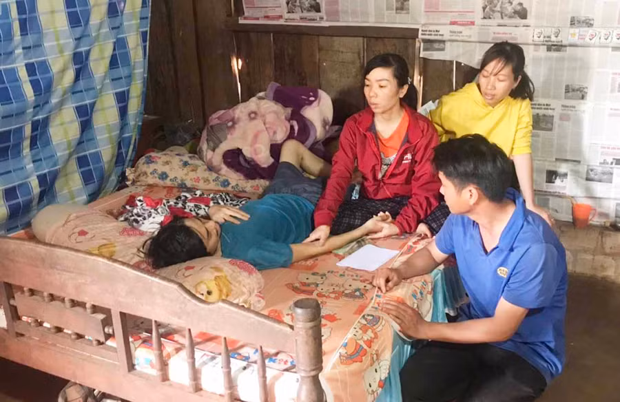 Chị Hoàng Thị Tươi chăm sóc chồng. Ảnh: Hà Phương