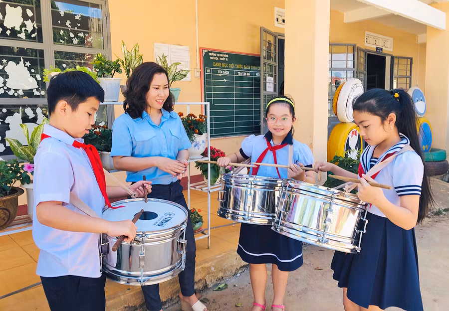 Cô Nguyễn Thúy Hằng hướng dẫn các đội viên đánh trống. Ảnh: Phan Lài