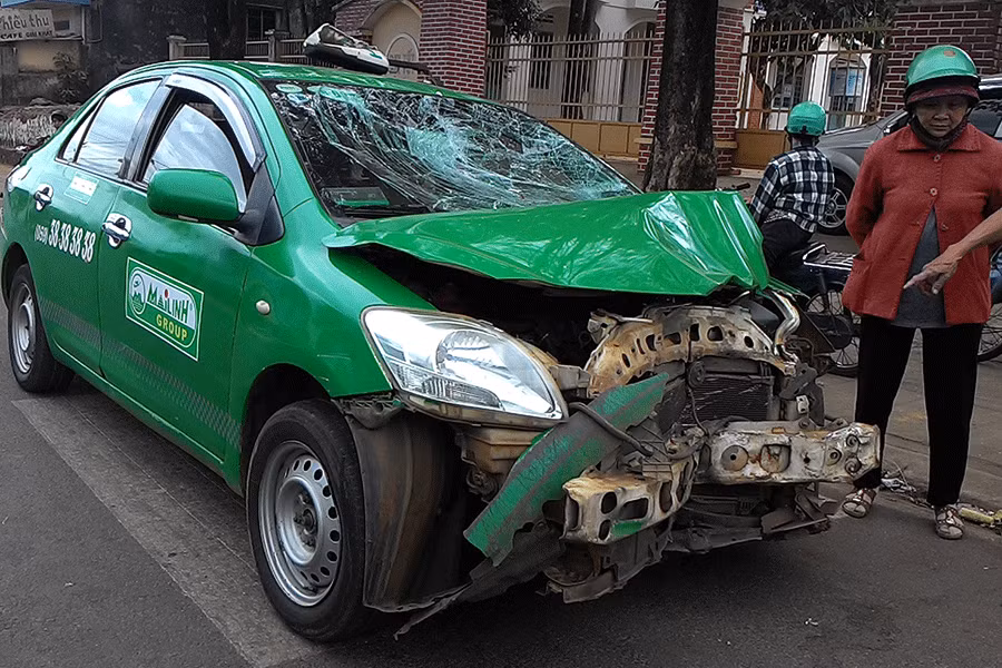 Phần đầu xe taxi biến dạng sau khi đấu đầu với xe mô tô. Ảnh: Nguyễn Giác