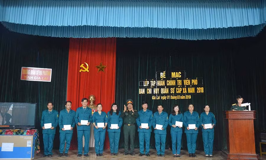  Đại tá Trần Văn Hoàn-Chính ủy Nhà trường cấp giấy cho các học viên. Ảnh: Huy Bắc