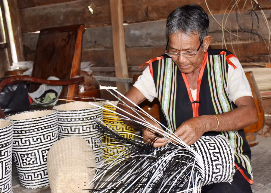 Già Đinh Nhiêu tỉ mẫn đan gùi. Ảnh: Trần Dung