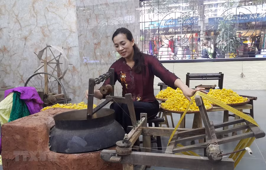 Kéo tơ tằm dệt lụa tại làng nghề Vạn Phúc, Hà Nội. (Ảnh: Đinh Thuận/TTXVN)