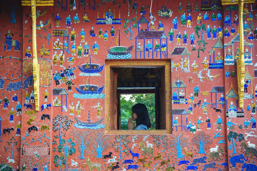  Những bức tường của Wat Xieng Thong lấp lánh bởi những mảng màu rực rỡ của gốm sứ khảm tinh tế, mang những ý nghĩa sâu sắc của đạo Phật