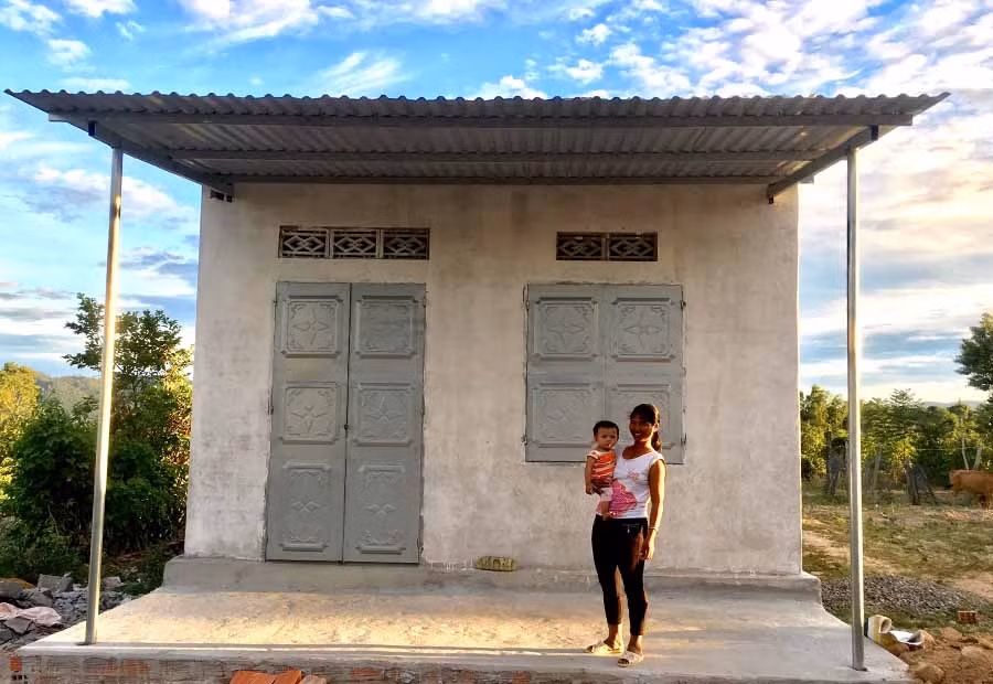  Chị Ksor HNil và cháu Ksor Dân trước ngôi nhà “Đại đoàn kết” vừa được Ủy ban MTTQ Việt Nam huyện xây tặng. Ảnh: H.L