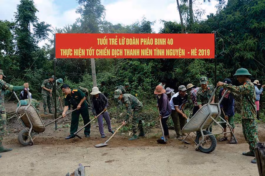  Cán bộ, chiến sĩ Lữ đoàn Pháo binh 40 (Quân đoàn 3) cùng người dân làng Hiêr (xã Ayun, huyện Mang Yang) dọn dẹp vệ sinh đường làng. Ảnh: T.B