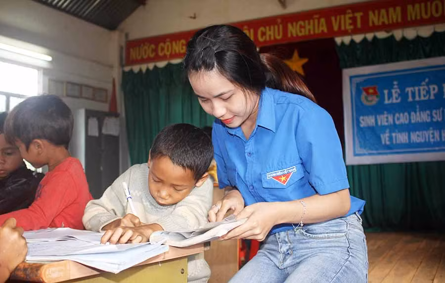 Các tình nguyện viên dạy học cho các em. Ảnh: Hà Phương