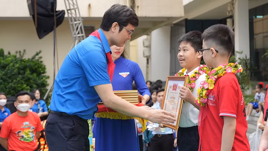 Anh Bùi Quang Huy trao Giải thưởng Kim Đồng cho các thiếu nhi tiêu biểu. Ảnh: Nhật Nam