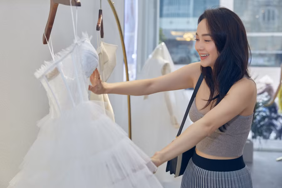 Minh Hằng diện trang phục đơn giản đến thử váy cưới, không giấu được niềm hạnh phúc trước những thiết kế dành riêng cho mình. Ảnh: NVCC
