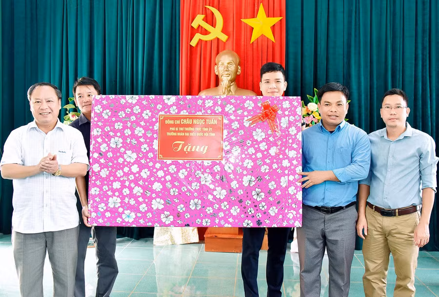 Phó Bí thư Thường trực Tỉnh ủy, Trưởng đoàn đại biểu Quốc hội tỉnh Châu Ngọc Tuấn (bìa trái) tặng quà cho hệ thống chính trị xã Đak Trôi, huyện Mang Yang. Ảnh: Đức Thụy