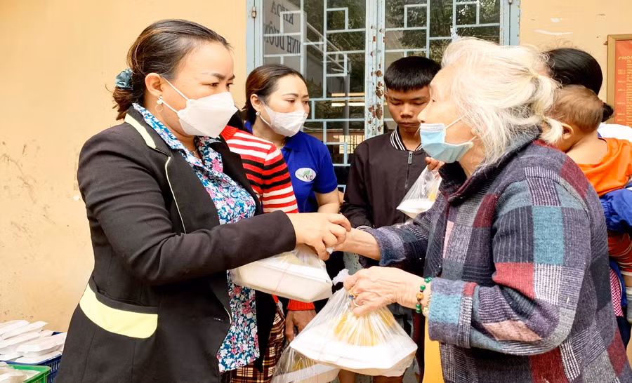 Chị Lý Thị Hồng Trị (bên trái) trao cơm cho bệnh nhân nghèo tại Bệnh viện Đa khoa tỉnh. Ảnh: Như Nguyện
