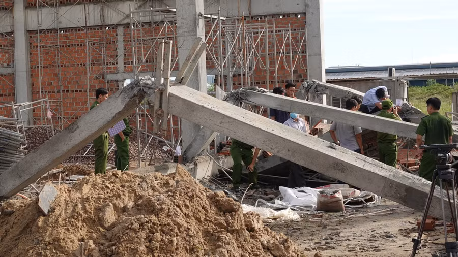 Các lực lượng chức năng đang khám nghiệm hiện trường bờ tường bị sập. Ảnh: Hoàng Trọng/Báo Thanh Niên