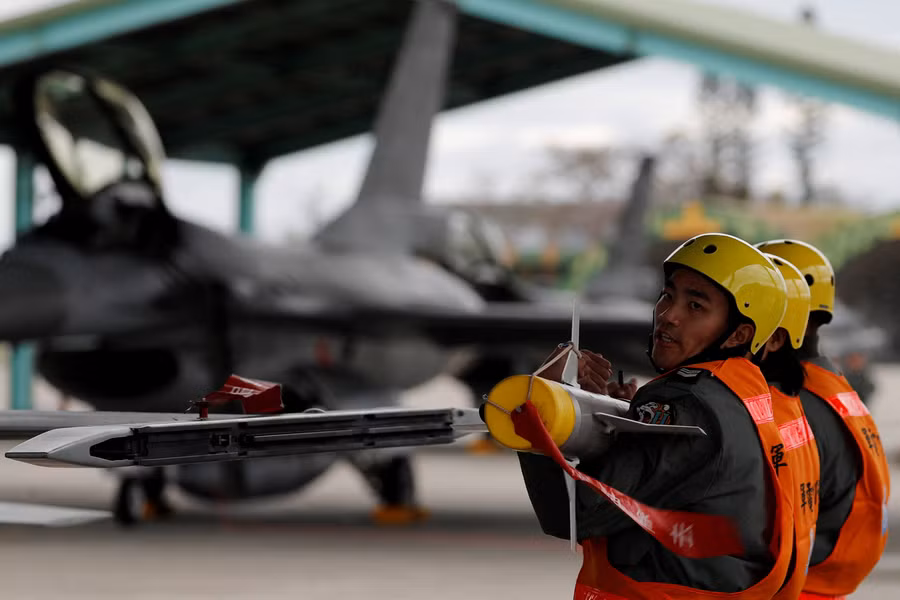 Các thành viên lực lượng không quân nâng tên lửa không đối không AIM-9 Sidewinder để đưa lên máy bay Northrop F-5 trong một cuộc diễn tập quân sự ở Đài Loan. Ảnh: Reuters