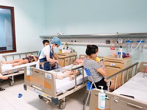 Nhân viên y tế chăm sóc cho trẻ mắc virus Adeno. (Ảnh: PV/Vietnam+)