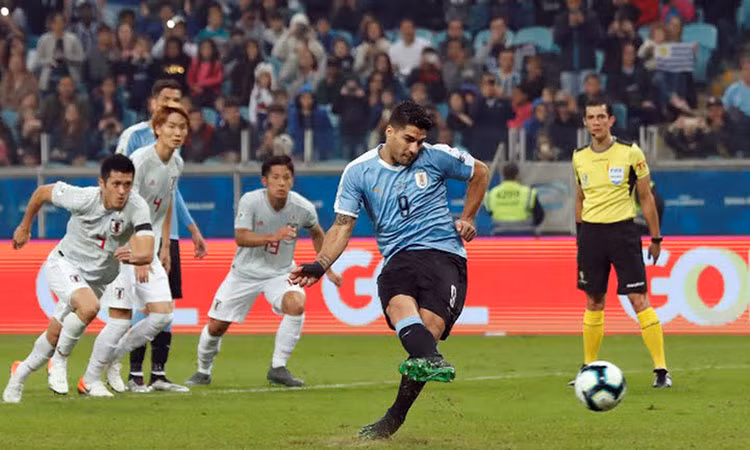  Suarez (áo xanh) gỡ hòa 1-1 trên chấm 11 met nhờ quyết định của VAR. Ảnh: AFP.