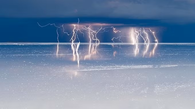  Trong những tháng mùa mưa ở tây nam Bolivia, làn nước mỏng đã biến Salar de Uyuni thành một tấm gương khổng lồ, phản chiếu bầu trời, chim hồng hạc, xe hơi và cả con người. Khí hậu ở đây rất khắc nghiệt, vào ban đêm trời lạnh buốt, có gió lớn và lượng mưa chỉ đạt mức 400 mm mỗi năm. Ảnh: Salar Andino.