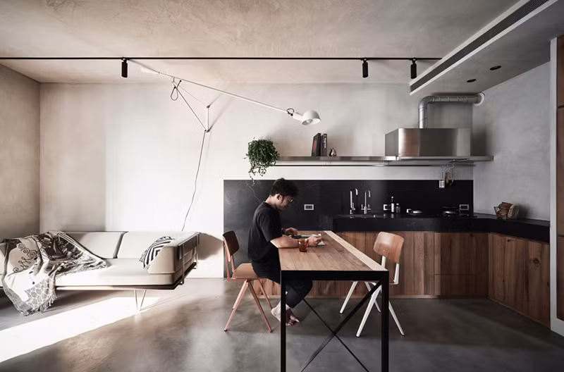 Tường nhà làm bằng bê tông mang đến cái nhìn tối giản, chân ghế sofa cách mặt sàn một khoảng nhất định khiến không gian không bị bức bối.