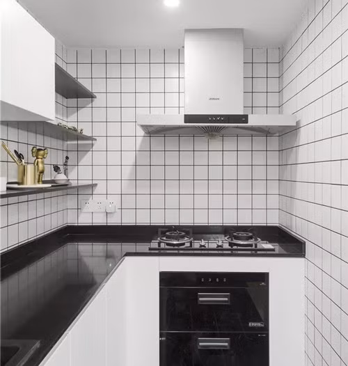 Khu bếp nhỏ dạng chữ L ốp gạch trắng đen nổi bật. Hệ thống khử mùi được gia chủ đặc biệt chú ý để không ám mùi nấu nướng ra cả không gian phòng khách.