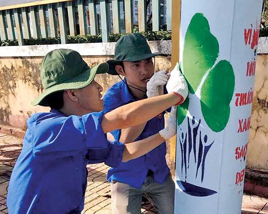  Đoàn viên thanh niên sơn vẽ tạo diện mạo mới cho các cột điện. Ảnh: Thủy Bình