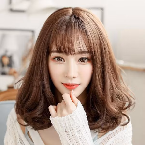  Tóc lob uốn xoăn cụp bồng bềnh kết hợp với mái mưa giúp bạn ăn gian độ dày cho tóc và trông trẻ trung hơn.