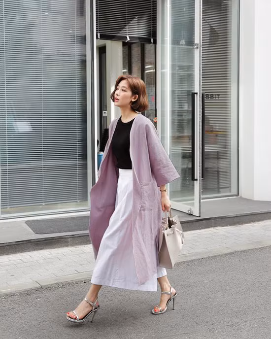 Set đồ mang lại hình ảnh thanh lịch cho nàng công sở với chân váy trắng đi cùng áo thun đen, áo choàng tím pastel.