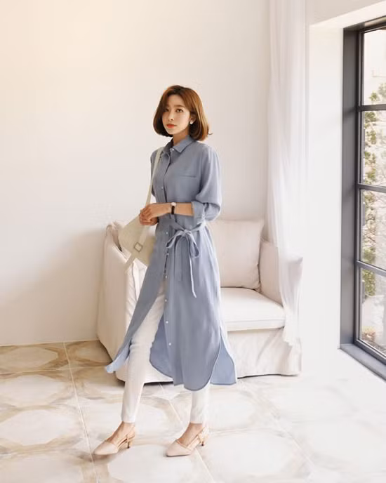  Để tránh đơn điệu khi diện sơ mi đến văn phòng, các chị em có thể chọn thêm các kiểu áo dáng dài mặc kèm đai lưng vải.