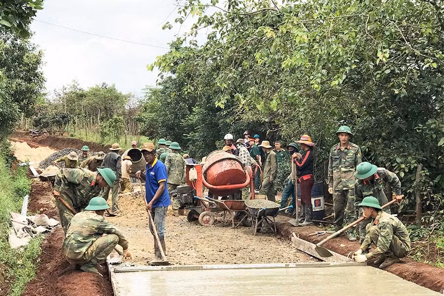 Các chiến sĩ Đội sản xuất (Cục Hậu cần Quân đoàn 3) cùng với nhân dân làng Rờng và làng Hlang (xã Hnol, huyện Đak Đoa) làm đường giao thông nông thôn. Ảnh: P.L