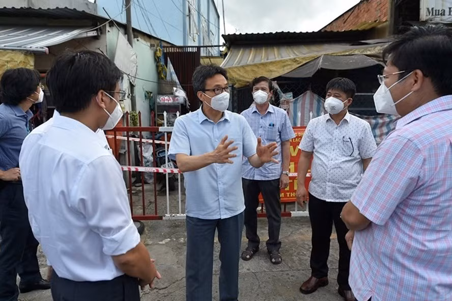 Phó Thủ tướng Vũ Đức Đam trao đổi với lãnh đạo quận Bình Tân (TPHCM) trước một khu nhà trọ công nhân đang bị phong toả. Ảnh: Đình Nam