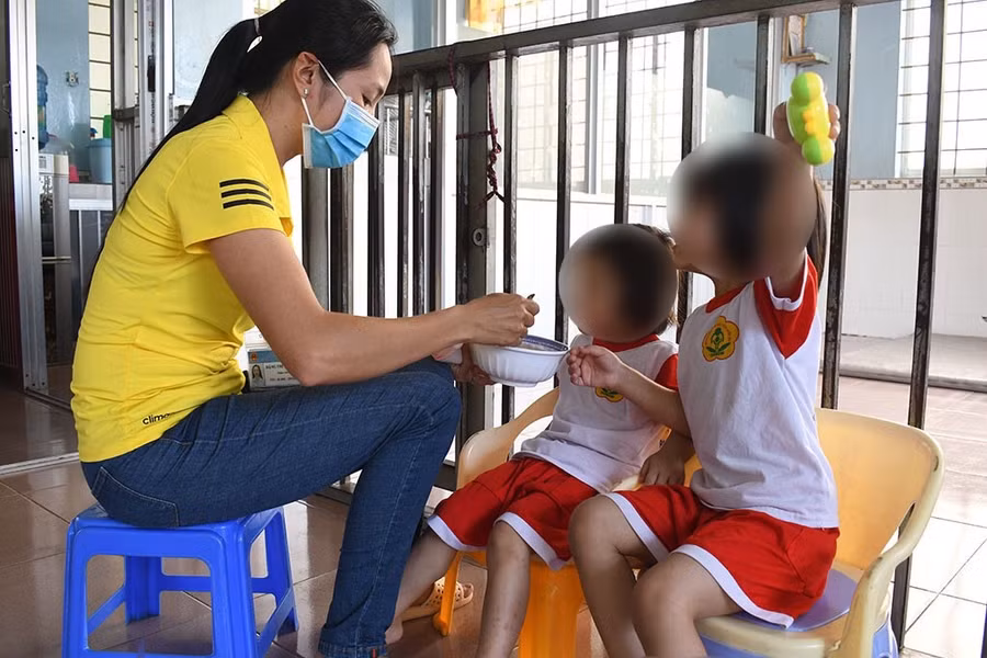 Chị Đặng Thị Mỹ Linh đang cho trẻ ăn. Ảnh: Quốc Lê