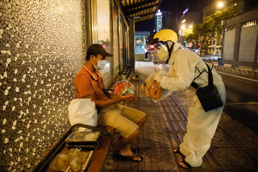 Hiền trao cho anh Phong phần hỗ trợ, giúp anh phần nào bớt khó khăn vượt qua mùa dịch. Ảnh: Lam Ngọc