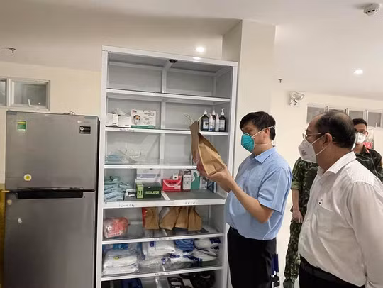 Bộ trưởng Bộ Y tế kiểm tra túi thuốc phát cho người mắc Covid-19 điều trị tại nhà tại phường 5, quận 8, TP HCM sáng 26-8 - Ảnh: Bộ Y tế