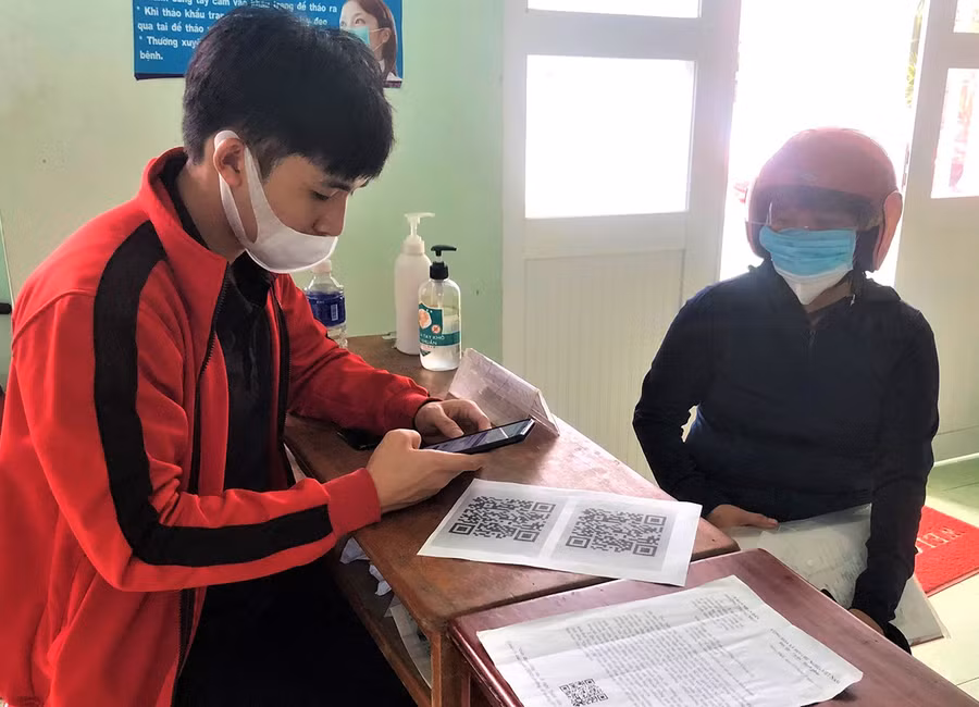 Cán bộ Phường Thống Nhất-TP. Pleiku chi tiền hỗ trợ cho lao động tư do. Ảnh: Đinh Yến