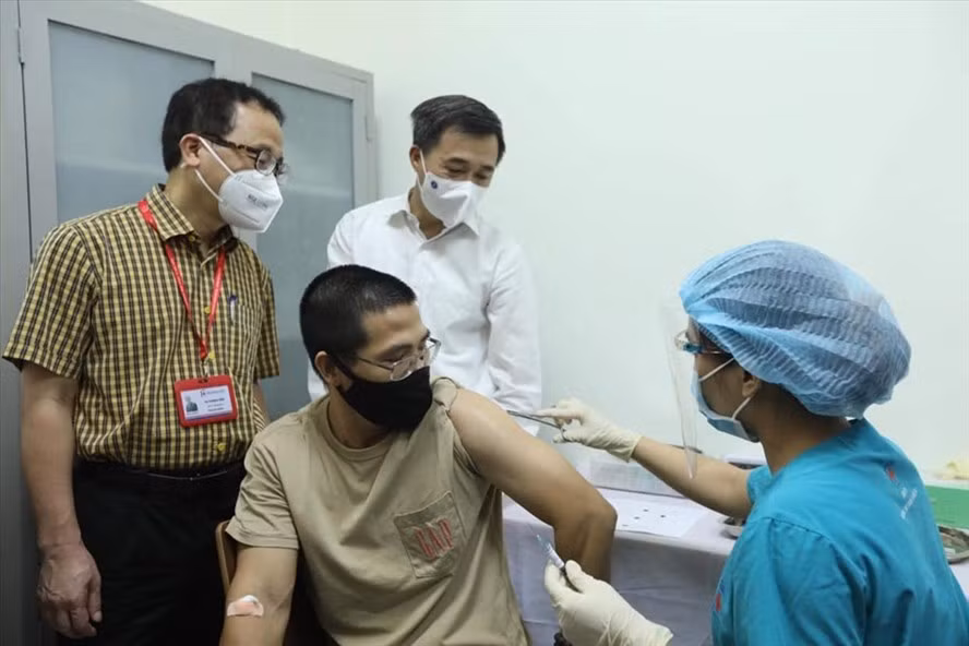 GS.TS Tạ Thành Văn và GS.TS Trần Văn Thuấn chứng kiến mũi tiêm thử nghiệm cho tình nguyện viên đầu tiên. Ảnh: Bộ Y tế