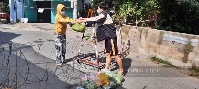 Sinh viên L cùng các sinh viên nhận hàng cứu trợ tại chốt phong tỏa đường số 2, khu phố 1, phường Tăng Nhơn Phú B (TP.Thủ Đức), chiều 1/8. Ảnh: Q.P